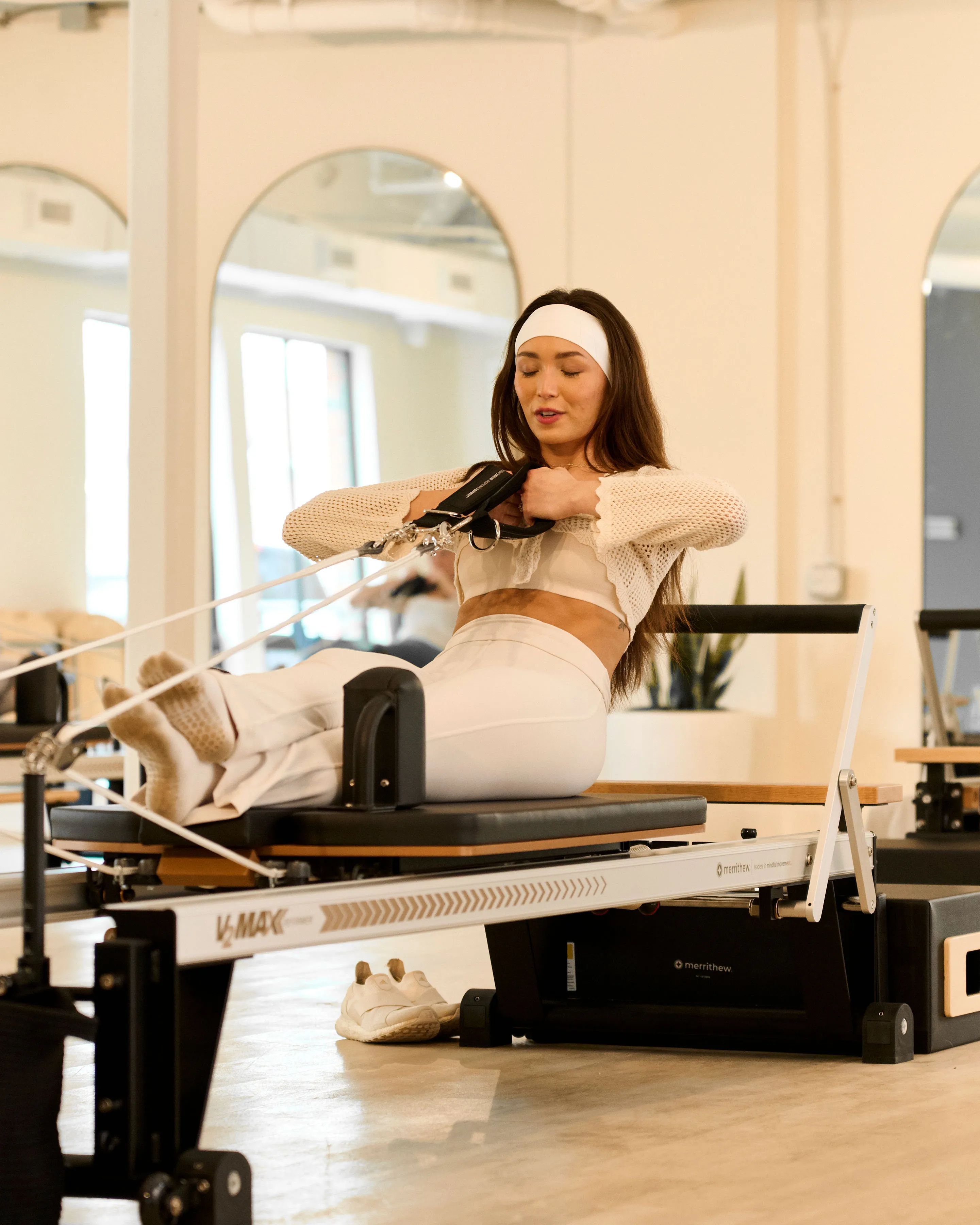 Woman doing reformer pilates at Flow Pilates Chapel Hill